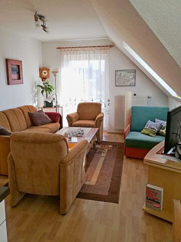 Wohnzimmer mit Flachbild TV und Couch + Sessel